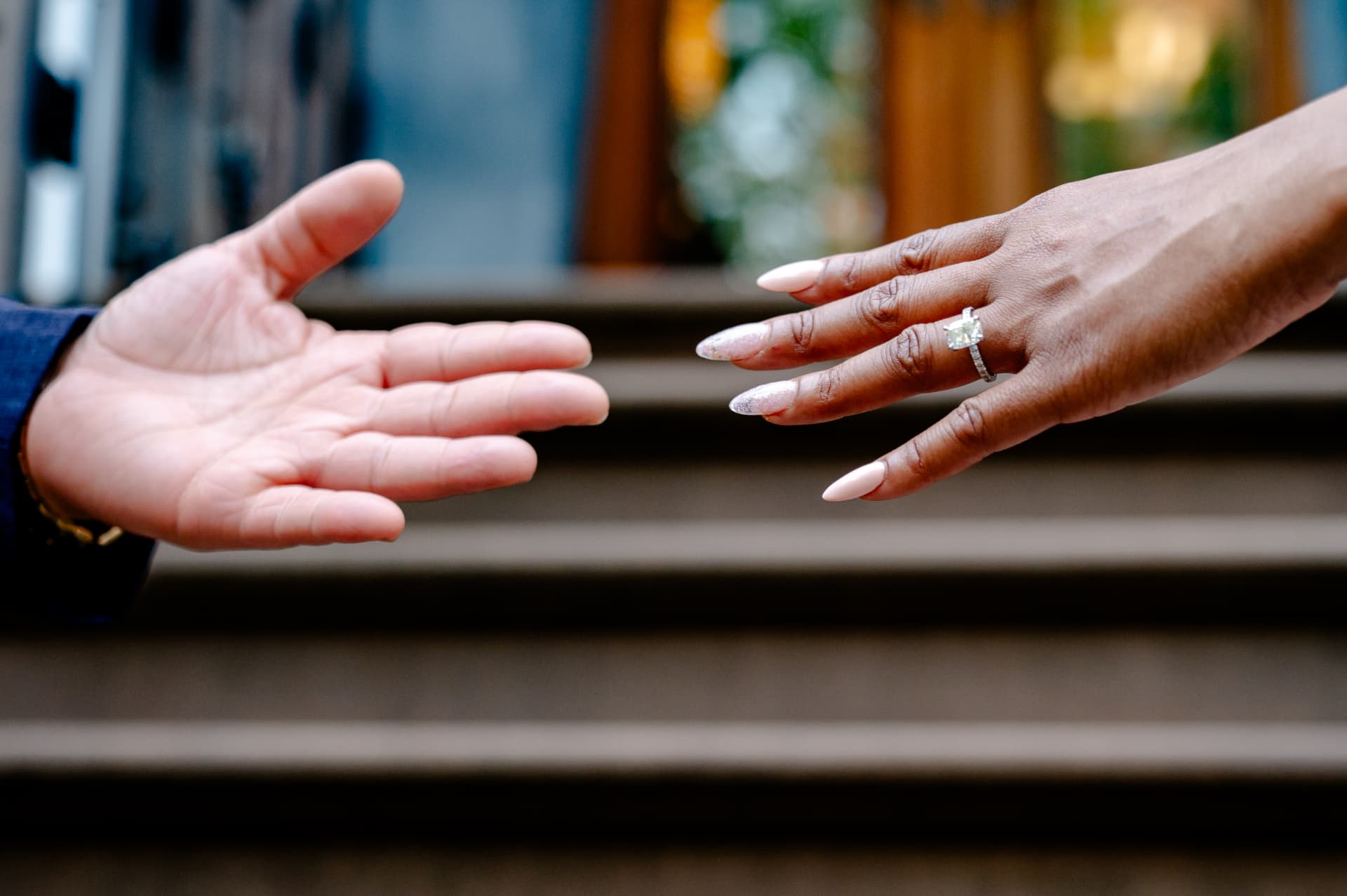 Ashley reaching toward Vincent, showing her engagement ring
